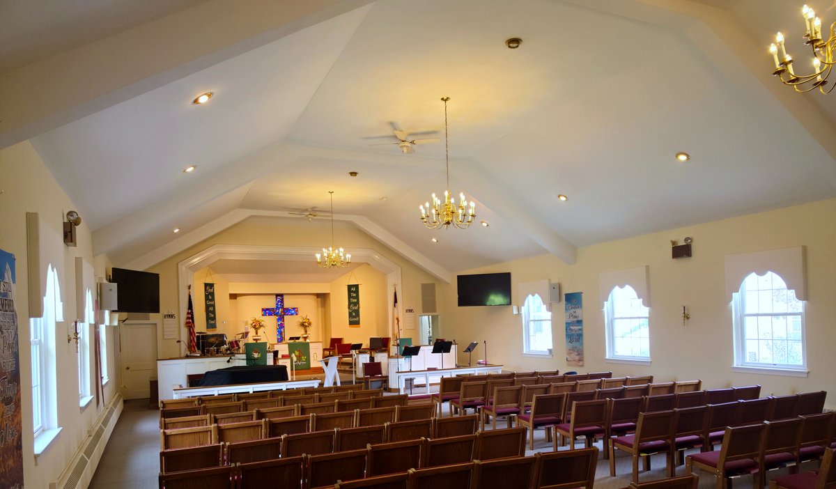 Messiah UMC sanctuary interior with pews and stained glass cross at altar